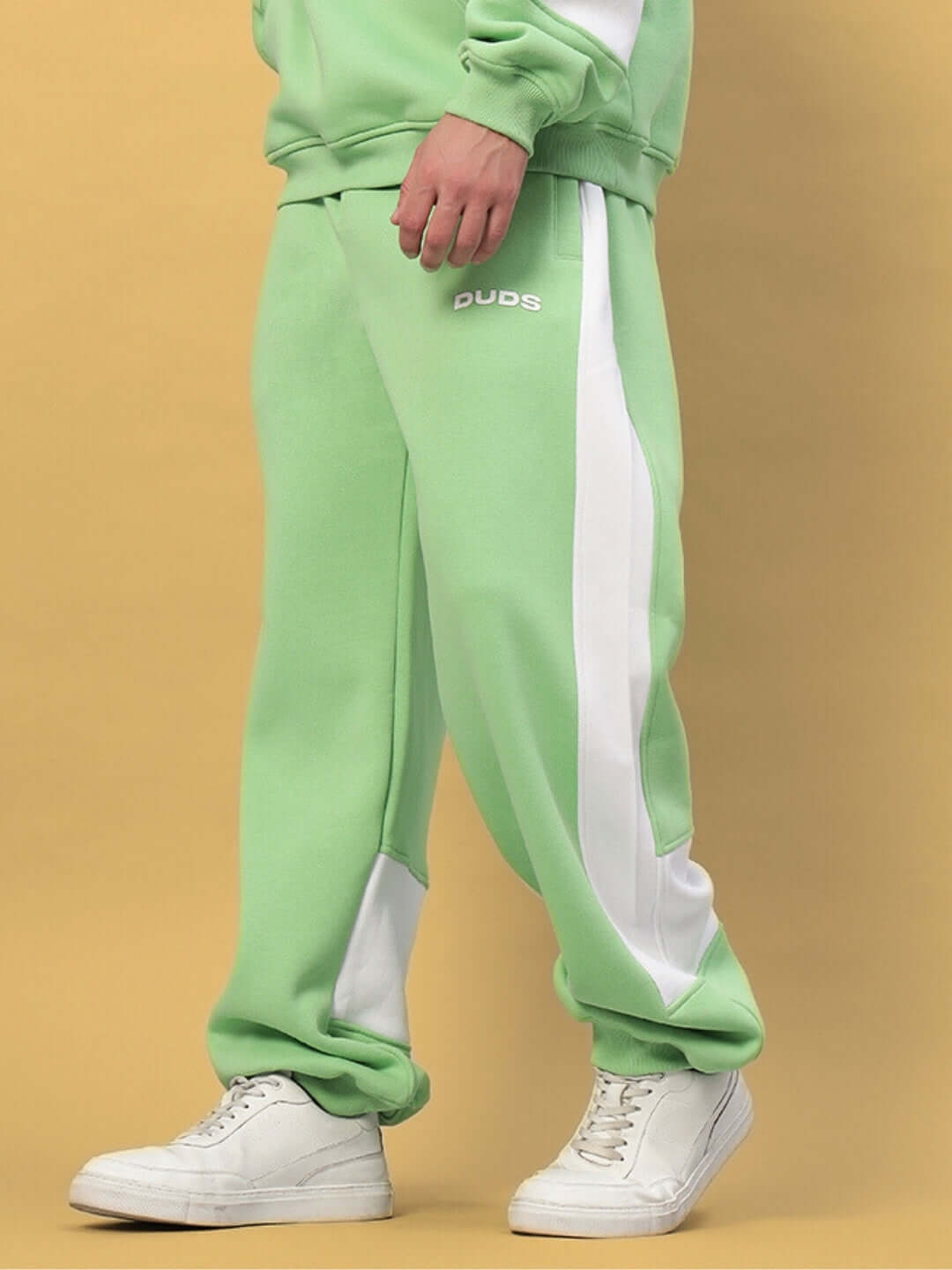 Person wearing MINTED BLISS FLEECE COLORBLOCK CARGO PANT GREEN WHITE with white sneakers