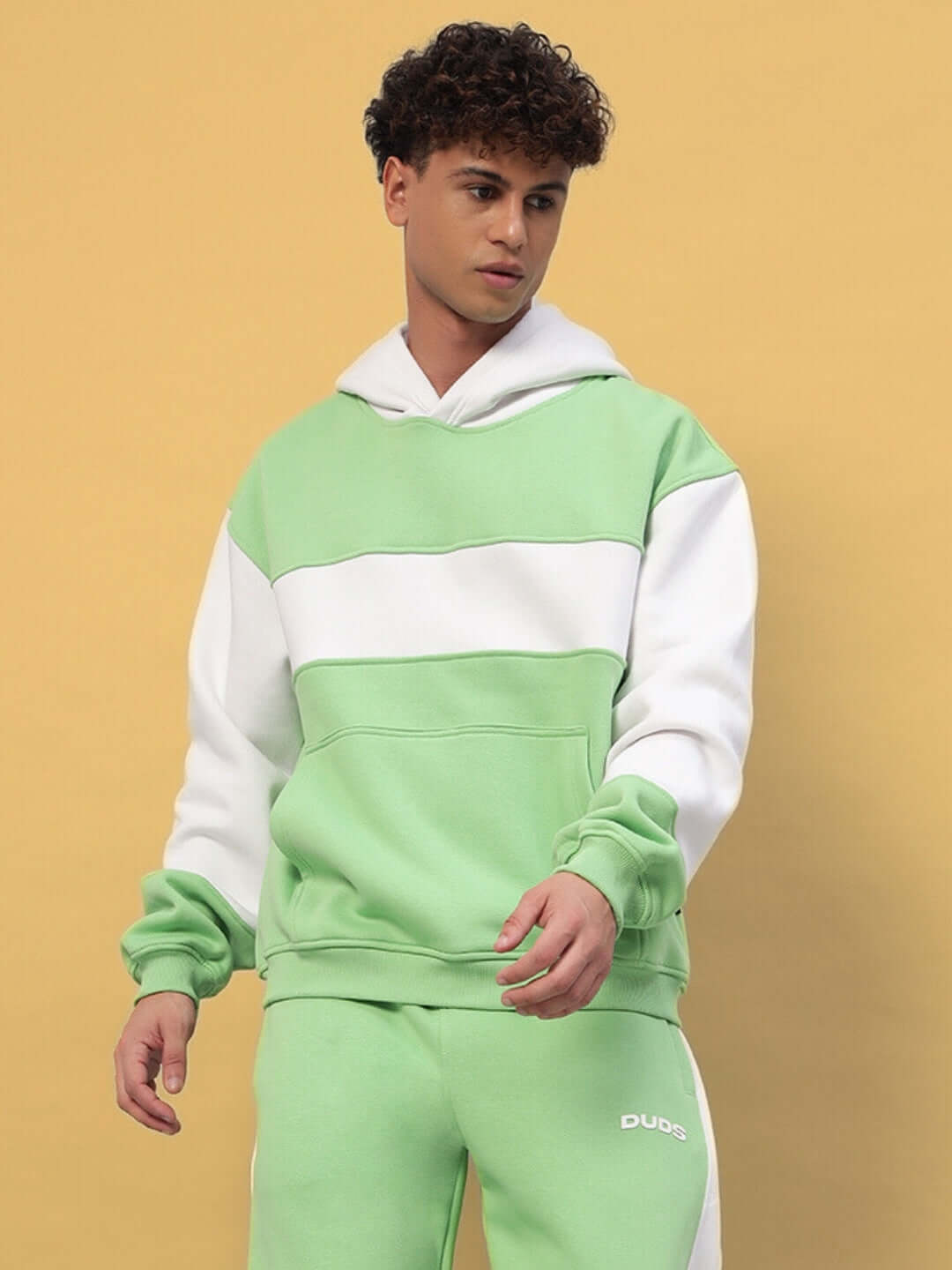 Man wearing Minted Bliss green-white colorblock hoodie from DUDS, made to order with custom fit option.