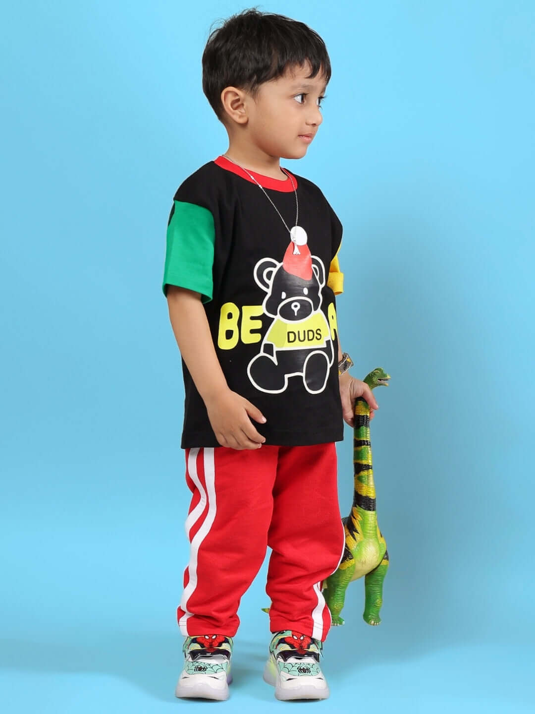 Child wearing MOCHA CO-ORD FOR BOYS & GIRLS BLACK RED outfit with dinosaur toy, stylish children's fashion.