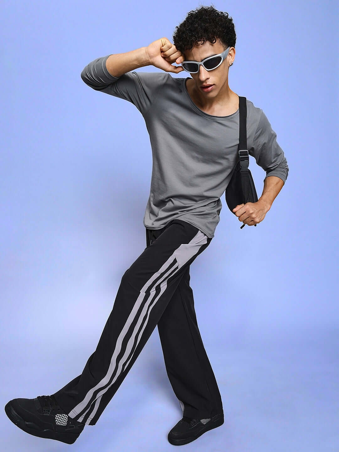 Man wearing MORGAN Relaxed Fit Cargo Pant in black with a stylish pose, grey shirt, and white sunglasses, showcasing custom fit options.