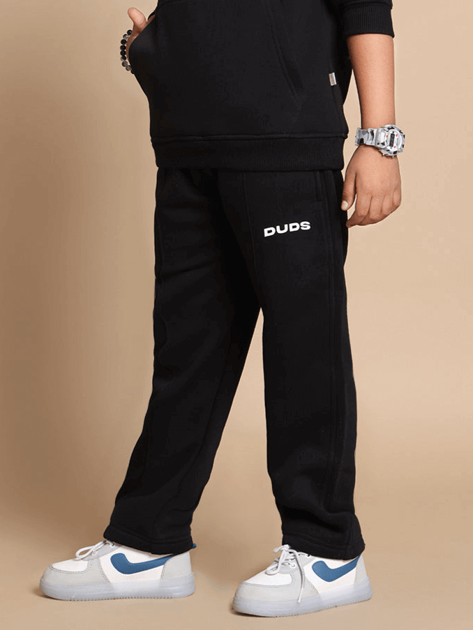 Child wearing MOLLY jogger pants in black by DUDS, customizable fit available, tailored with care, ideal for boys and girls.
