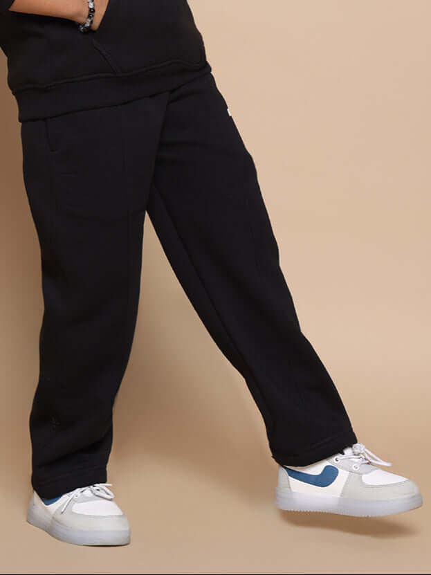 Boy wearing black jogger pants, styled with white sneakers. Made-to-order by DUDS, available in custom sizes for boys and girls.