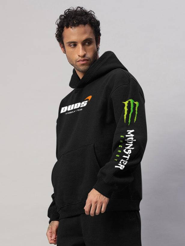 Model wearing MONSTER DRINK FLEECE HOODIE BLACK with DUDS brand logo