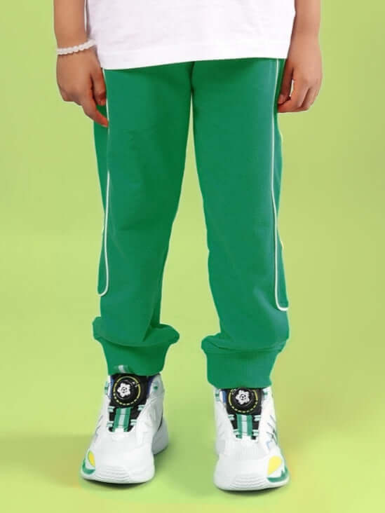 Child wearing green MOON NIGHT JOGGER FOR BOYS & GIRLS GREEN with trendy sneakers, showcasing fashionable streetwear.