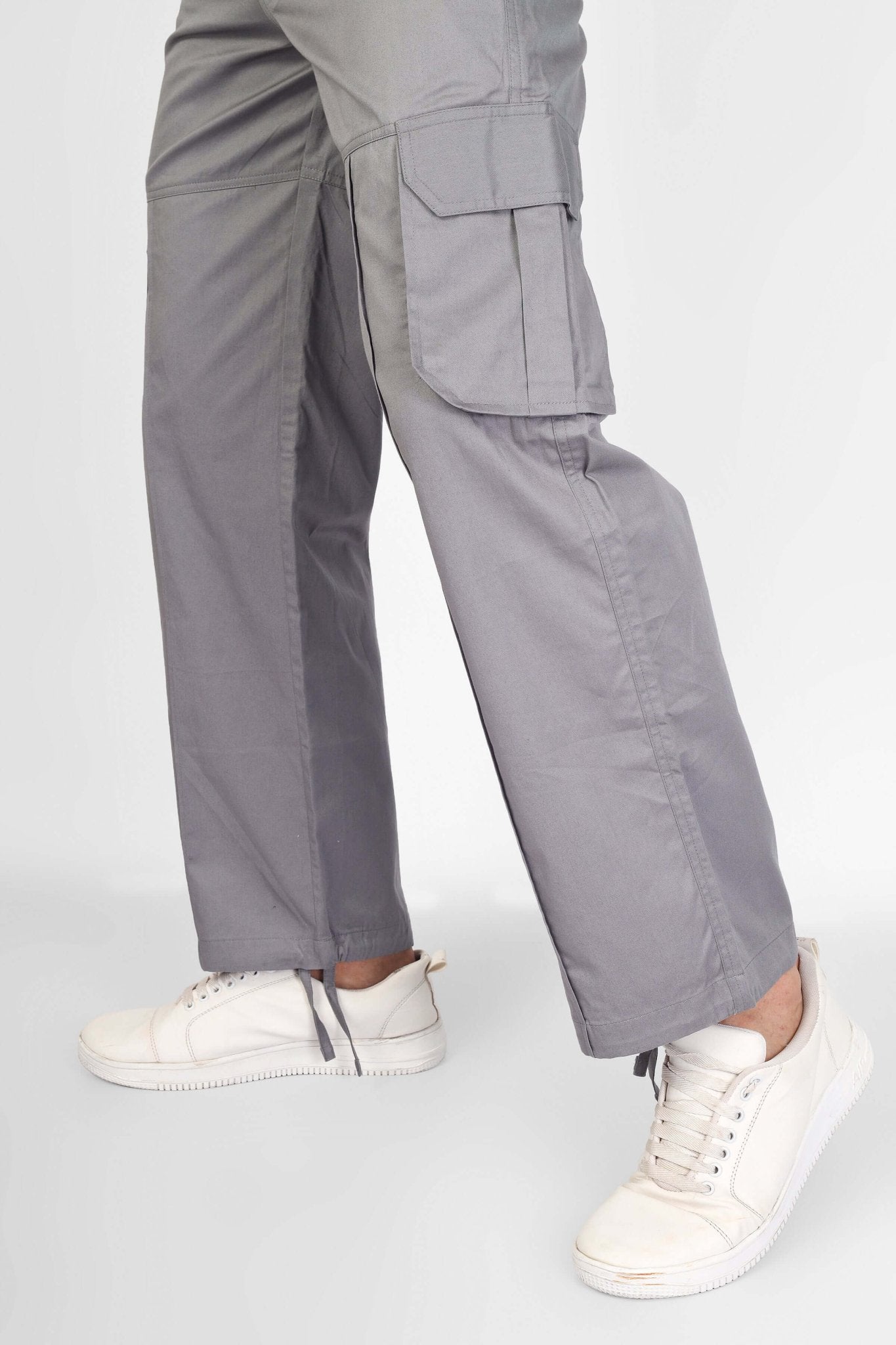 Side view of MOON STONE CARGO PANTS WITH 6 CARGO POCKET in grey, featuring comfortable fit and casual style with white sneakers.