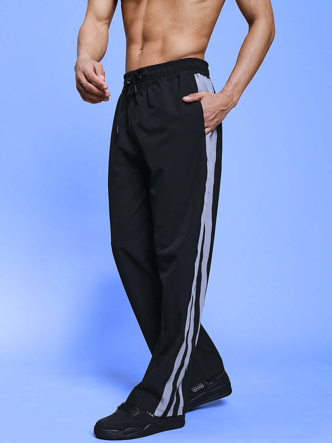 Model wearing MORGAN RELAXED FIT CARGO PANT BLACK with casual top on blue background