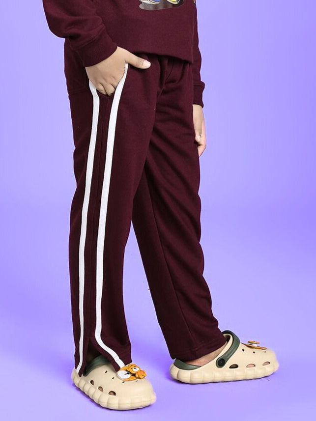 Child wearing MOSCOW RELAXED FIT JOGGER FOR BOYS AND GIRLS MAROON with white stripe on purple background