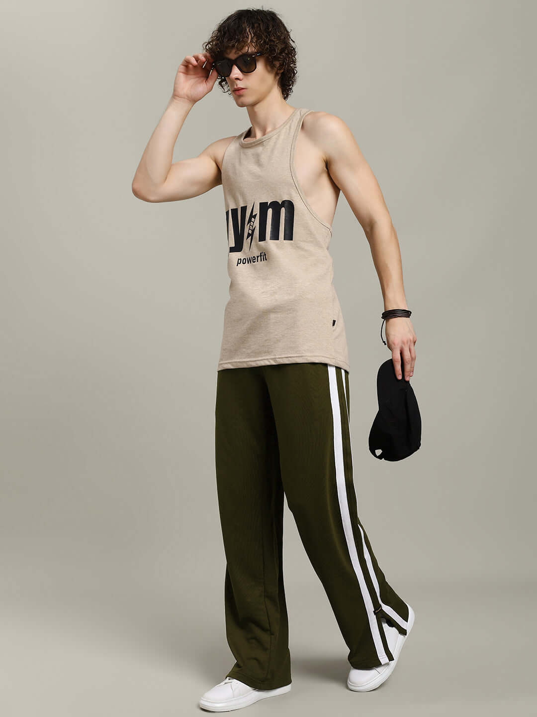 Model wearing MOSCOW RELAXED FIT JOGGERS OLIVE GREEN with tank top, showcasing athleisure style.