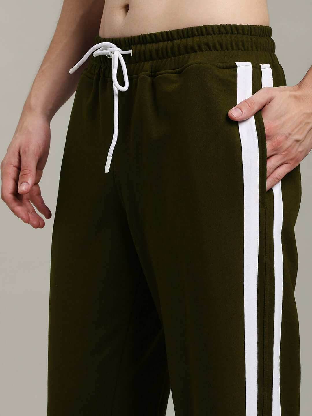 Model wearing MOSCOW RELAXED FIT JOGGERS OLIVE GREEN with white drawstring and side stripes, showcasing stylish athleisure look.