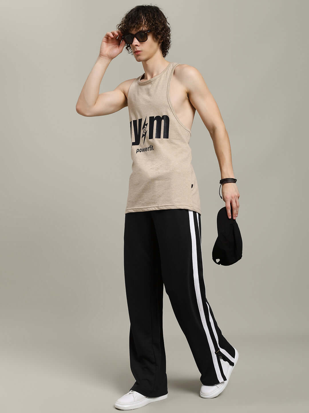 Model wearing MOSCOW RELAXED FIT JOGGERS BLACK, paired with a beige tank top, showcasing a casual and stylish outfit.