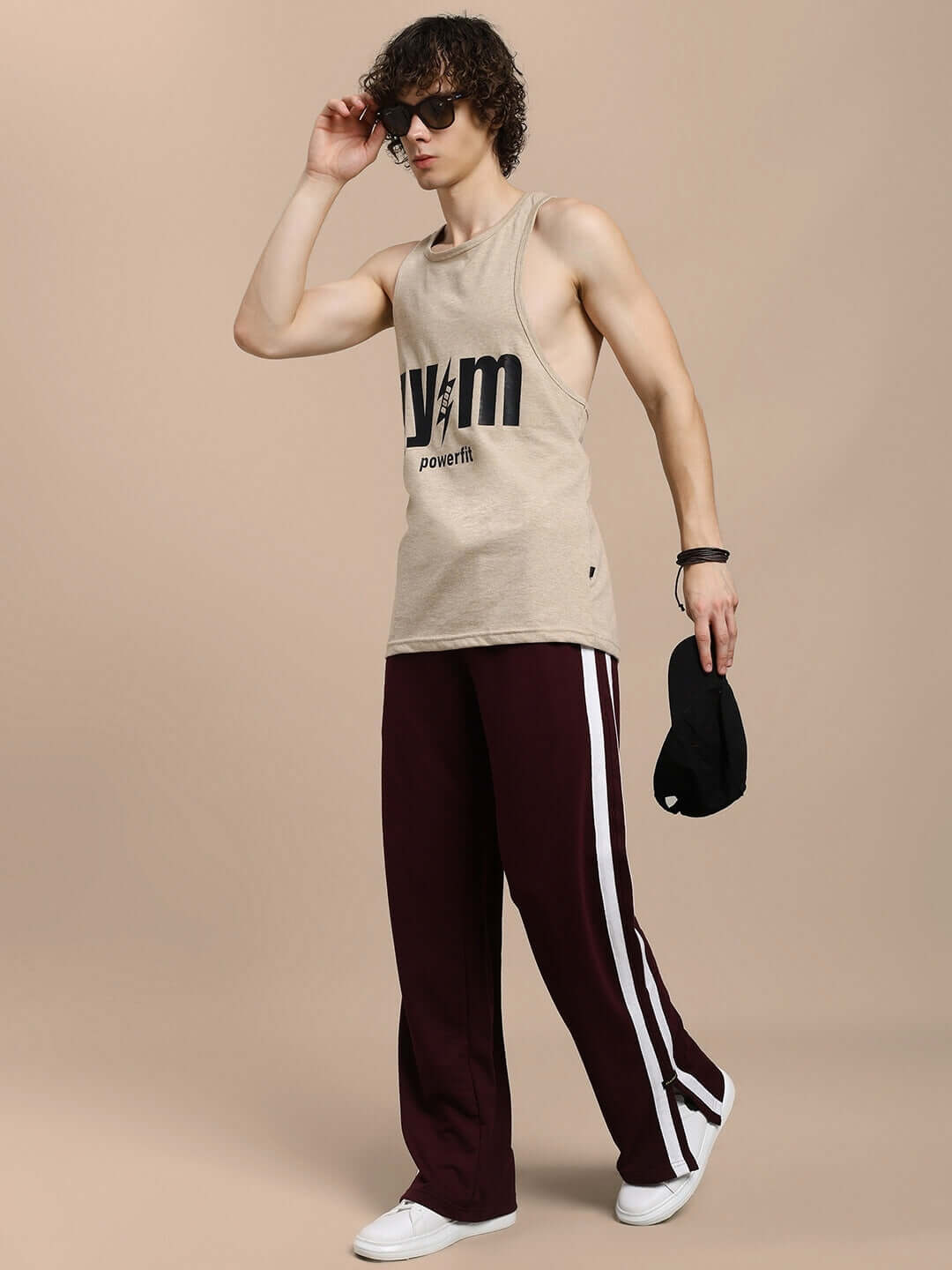 Man wearing MOSCOW RELAXED FIT JOGGERS MAROON in a stylish pose with sunglasses.