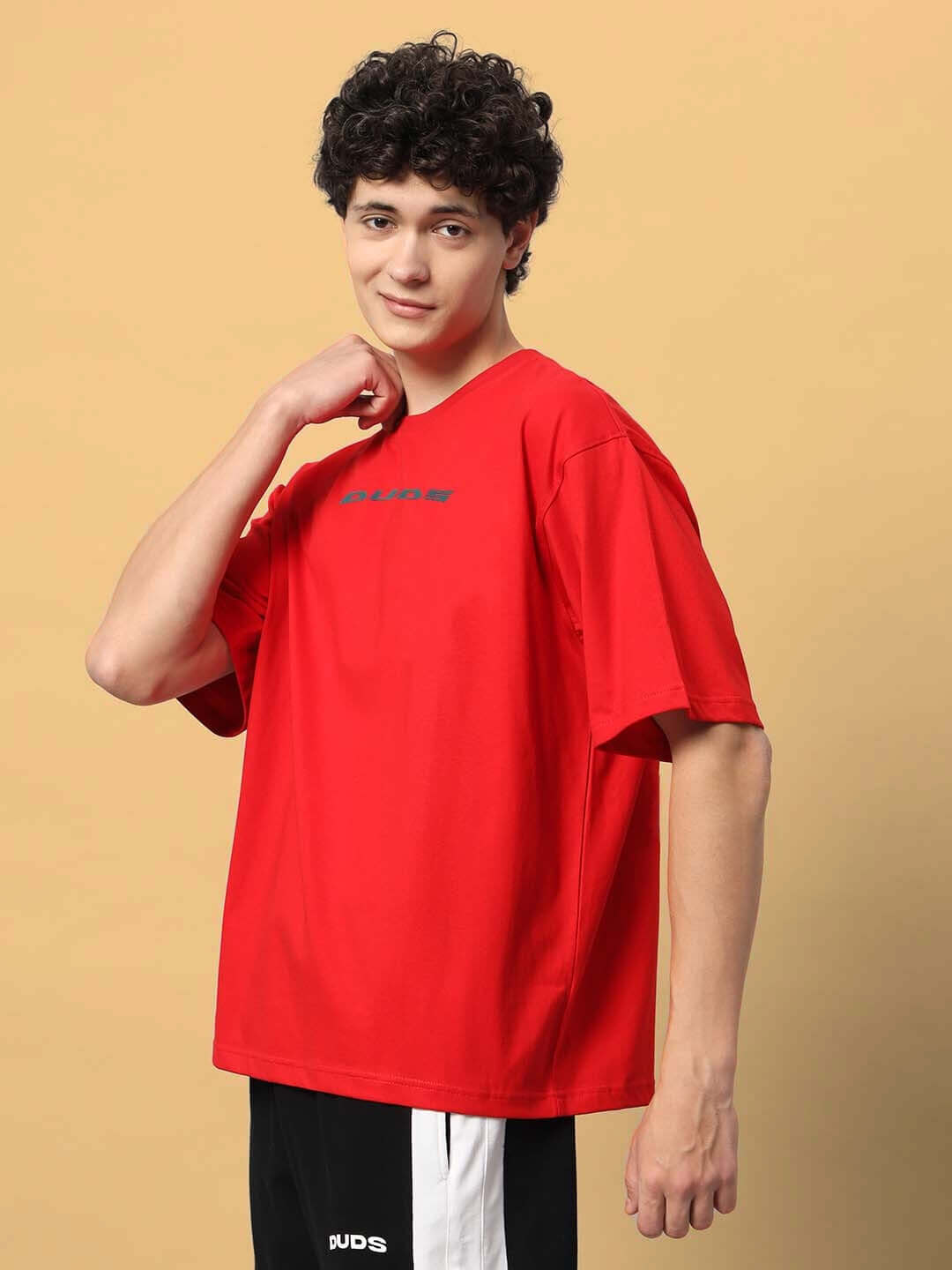 Model wearing red Mudflap Girl oversized T-shirt, customizable for perfect fit, by DUDS. Ideal for casual, comfortable styling.