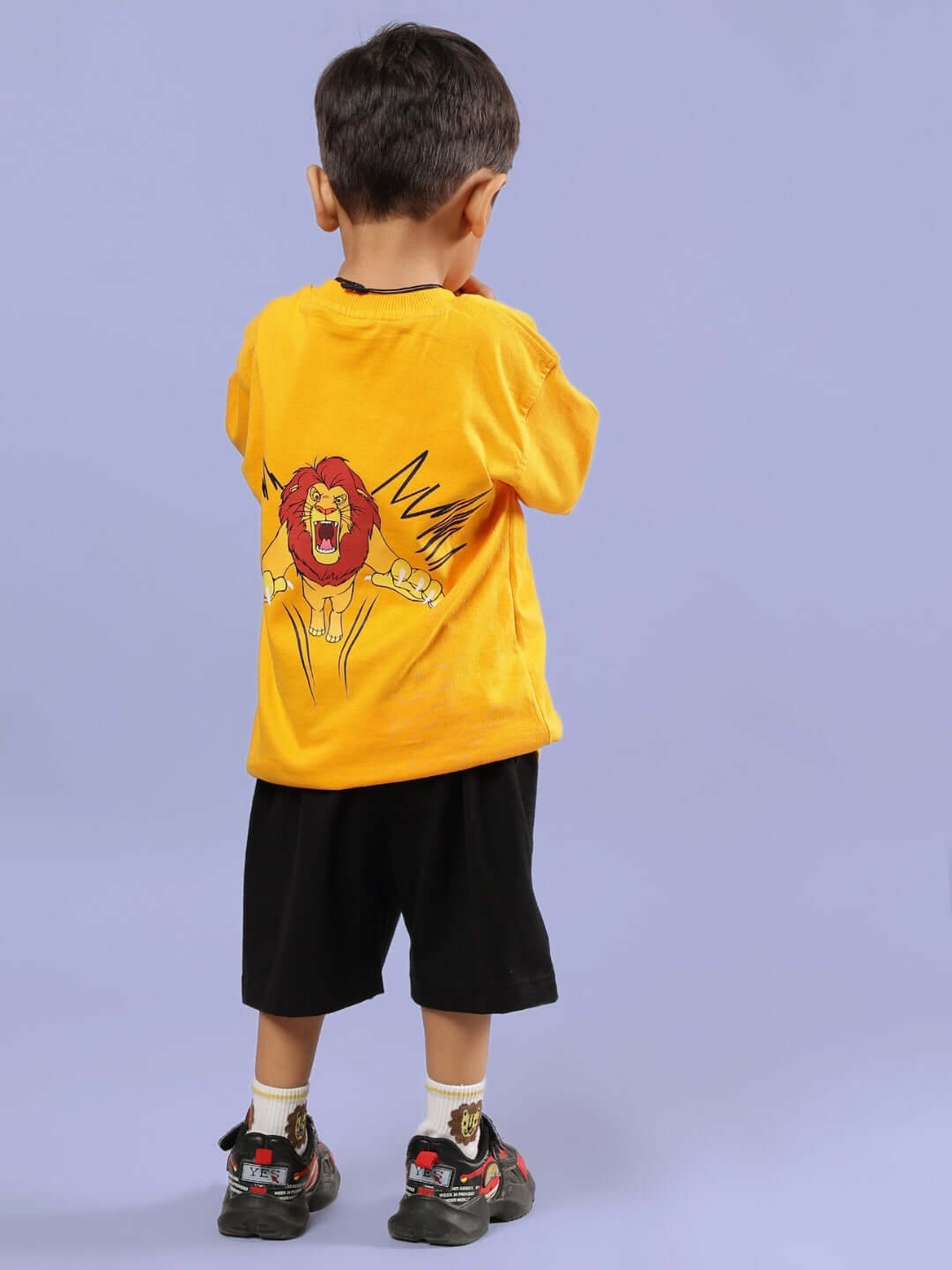 Child wearing MUFASA CO-ORD FOR BOYS & GIRLS MUSTARD-BLACK outfit with lion print on back.