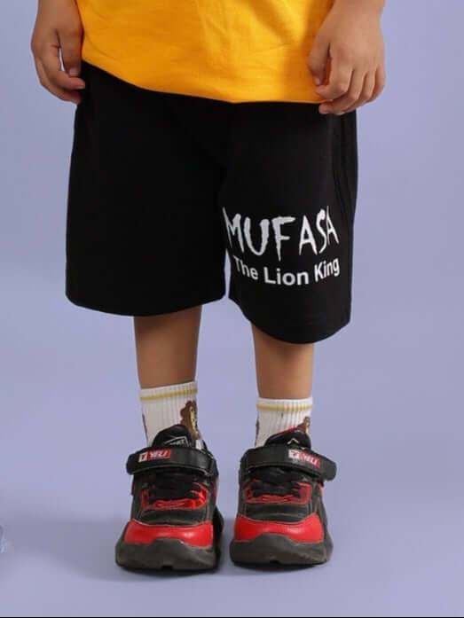 MUFASA SHORTS FOR BOYS & GIRLS BLACK with 'The Lion King' text, worn by child with red sneakers and lion-themed socks.