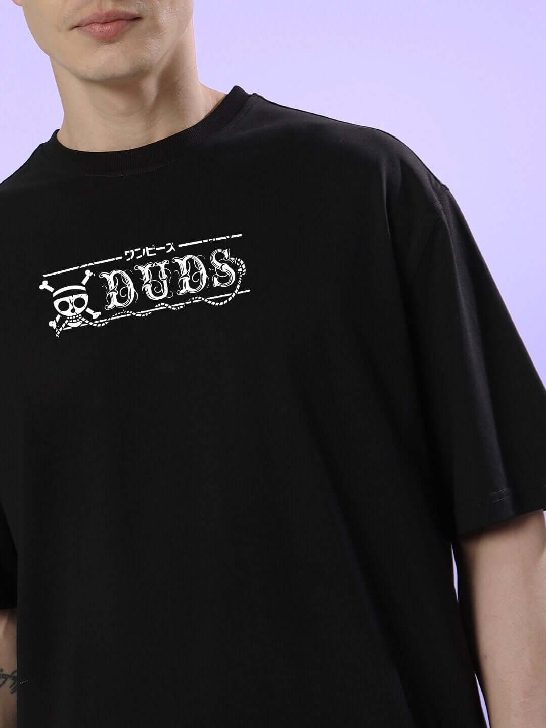 Model wearing MUGIWARA PRINTED OVERSIZED T-SHIRT BLACK featuring bold Straw Hat design on black fabric.