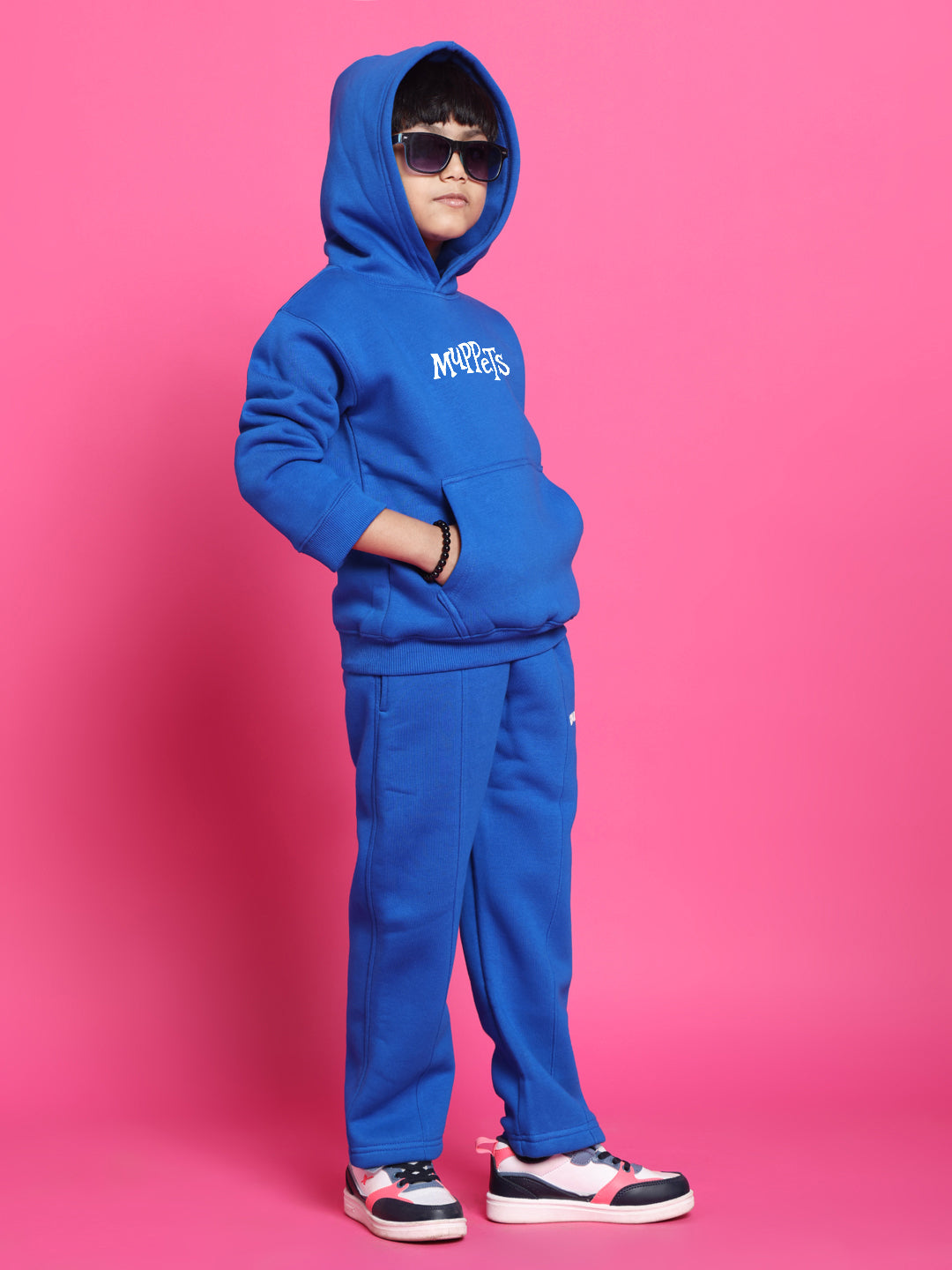 Child in Muppets Fleece Co-Ord for Boys Girls Royal Blue hoodie, standing with hands in pockets and wearing sunglasses.