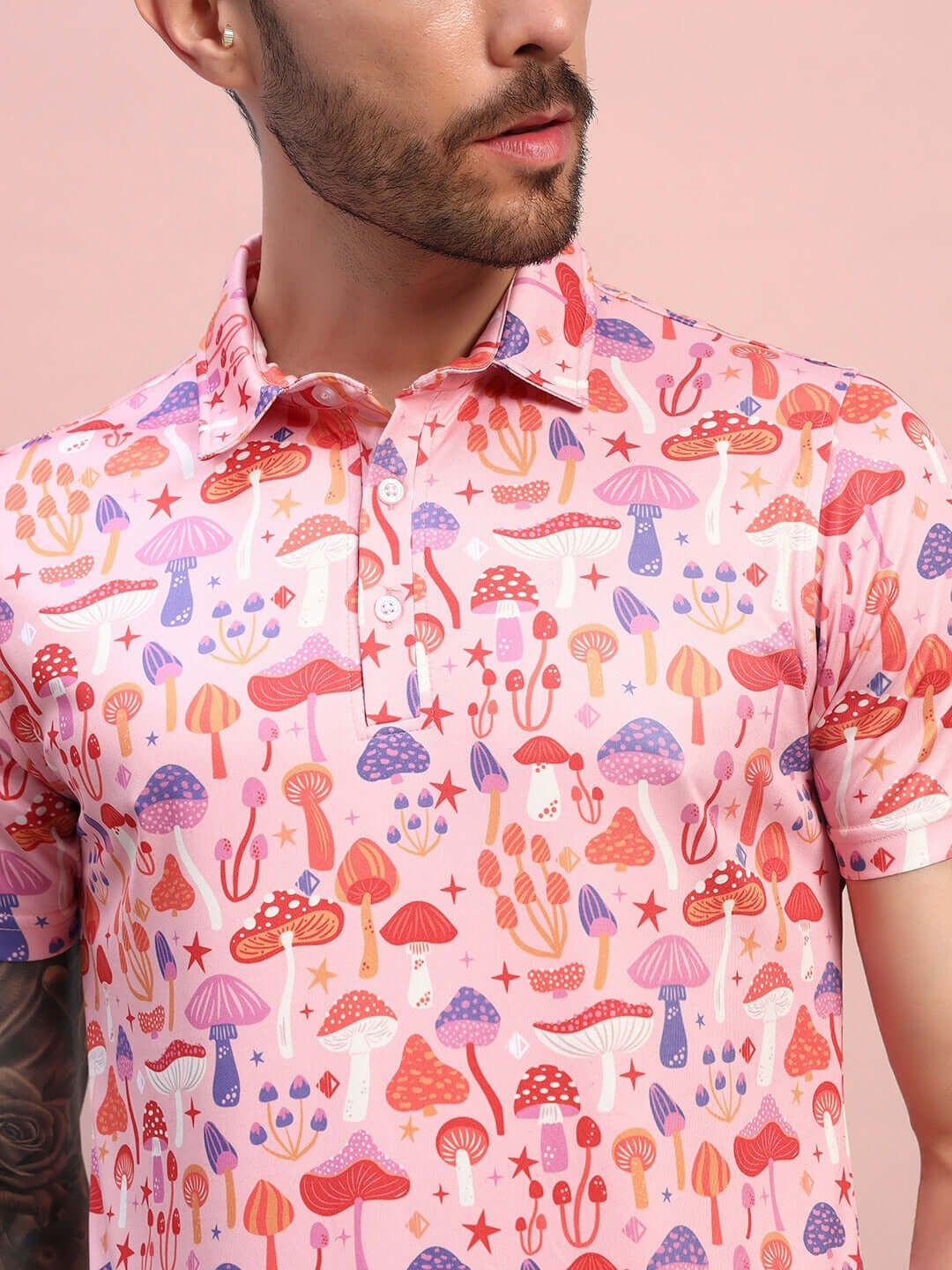 Pink multi-colored mushroom print T-shirt in sports polyester fabric, worn by a man, showcasing vibrant, playful designs.
