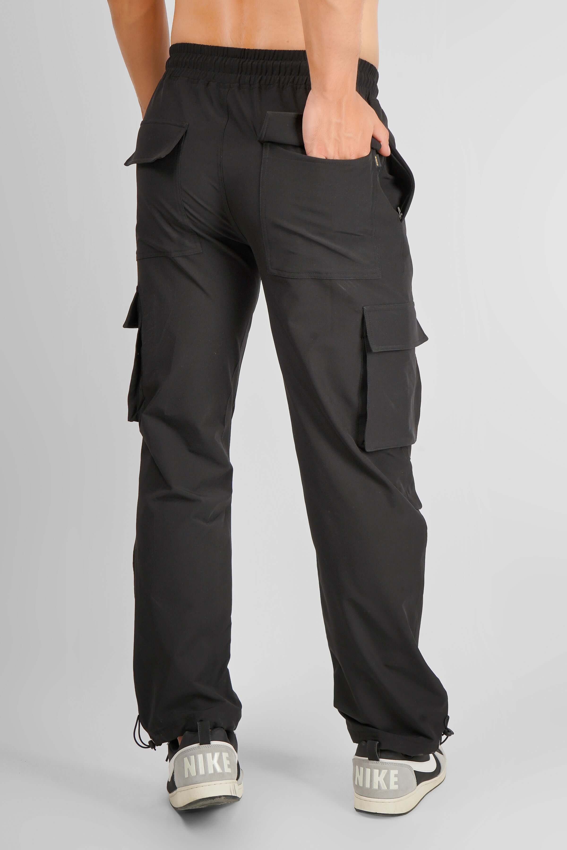 Back view of Myriad Relaxed Fit Cargo Pants in dark grey featuring multiple pockets, customizable sizing, and comfortable fit.