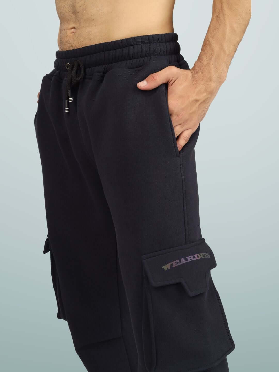 Man wearing 5 POCKET FLEECE SOLID CARGO PANT NAVY BLUE, showcasing side pockets and comfortable fit, perfect for stylish urban wear.
