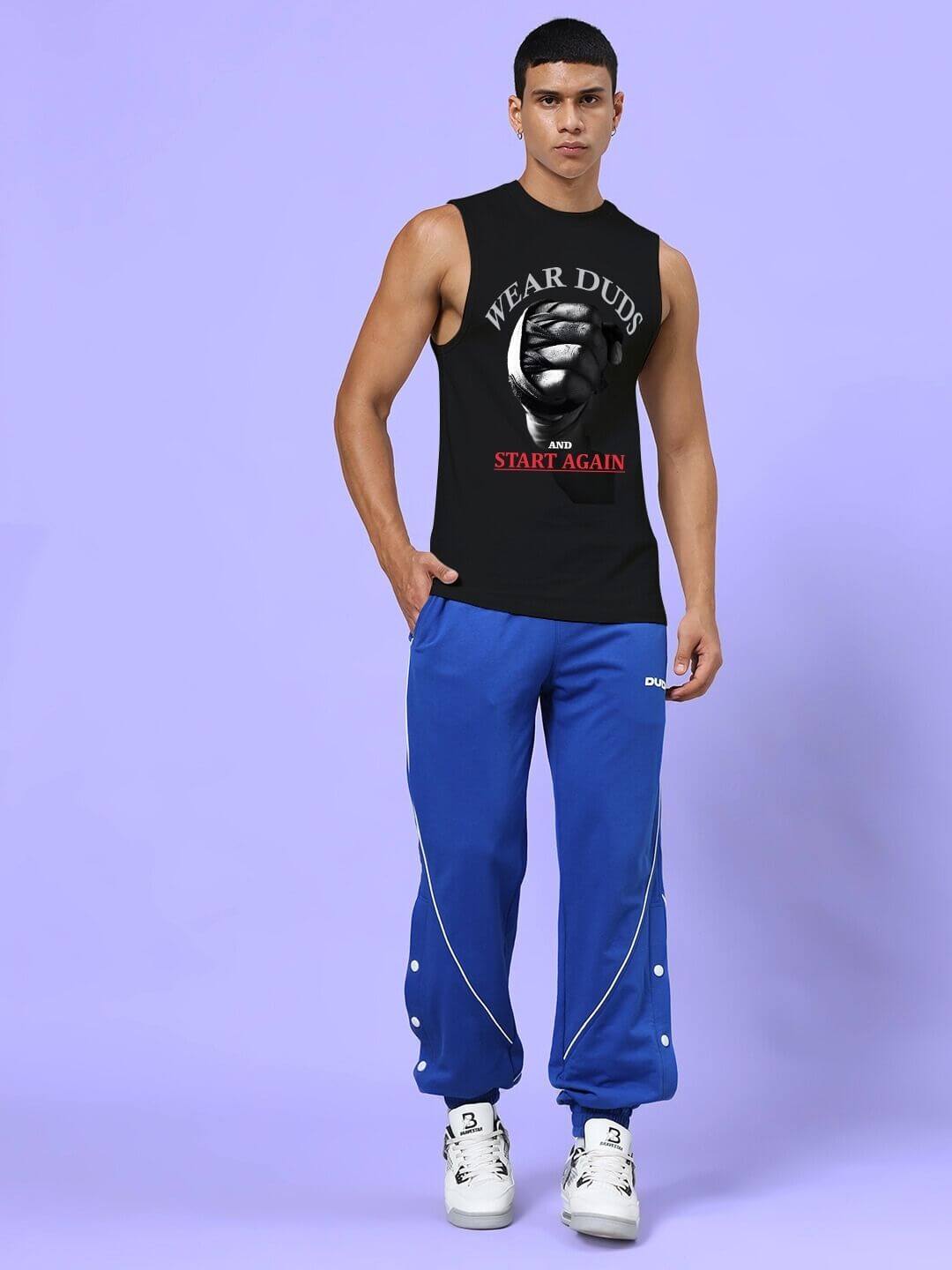 Man wearing NEVER QUIT START AGAIN GYM SLEEVELESS T-SHIRT BLACK with motivational slogan and blue pants, perfect for fitness sessions.