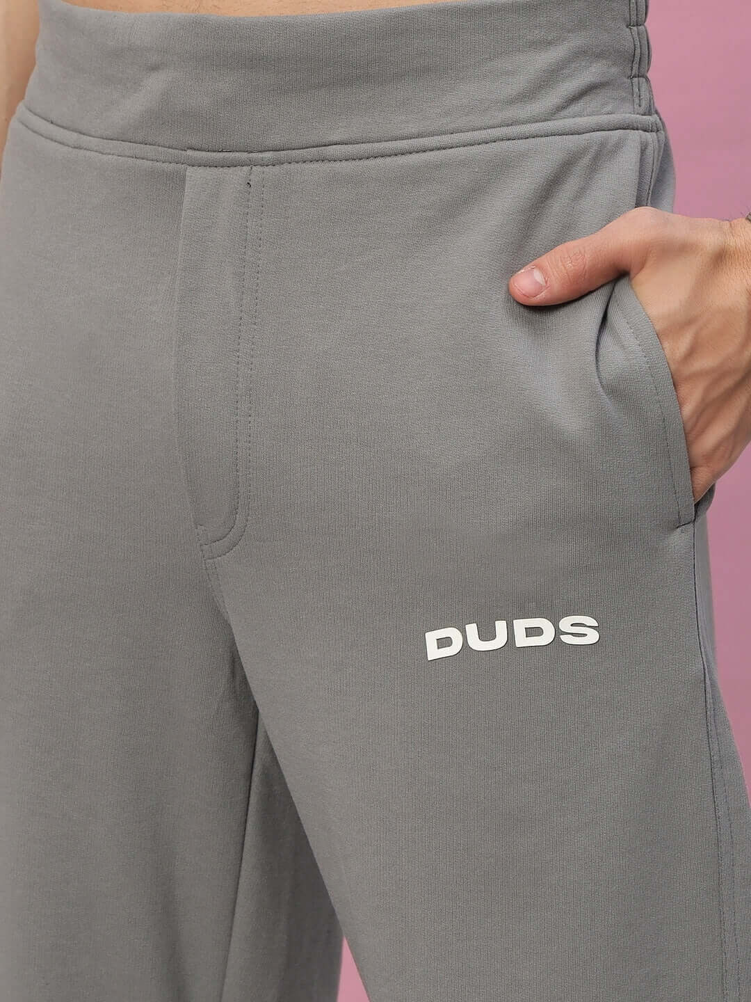 Grey New Era Relaxed Fit Joggers by DUDS with hand in pocket, showcasing comfort and style.