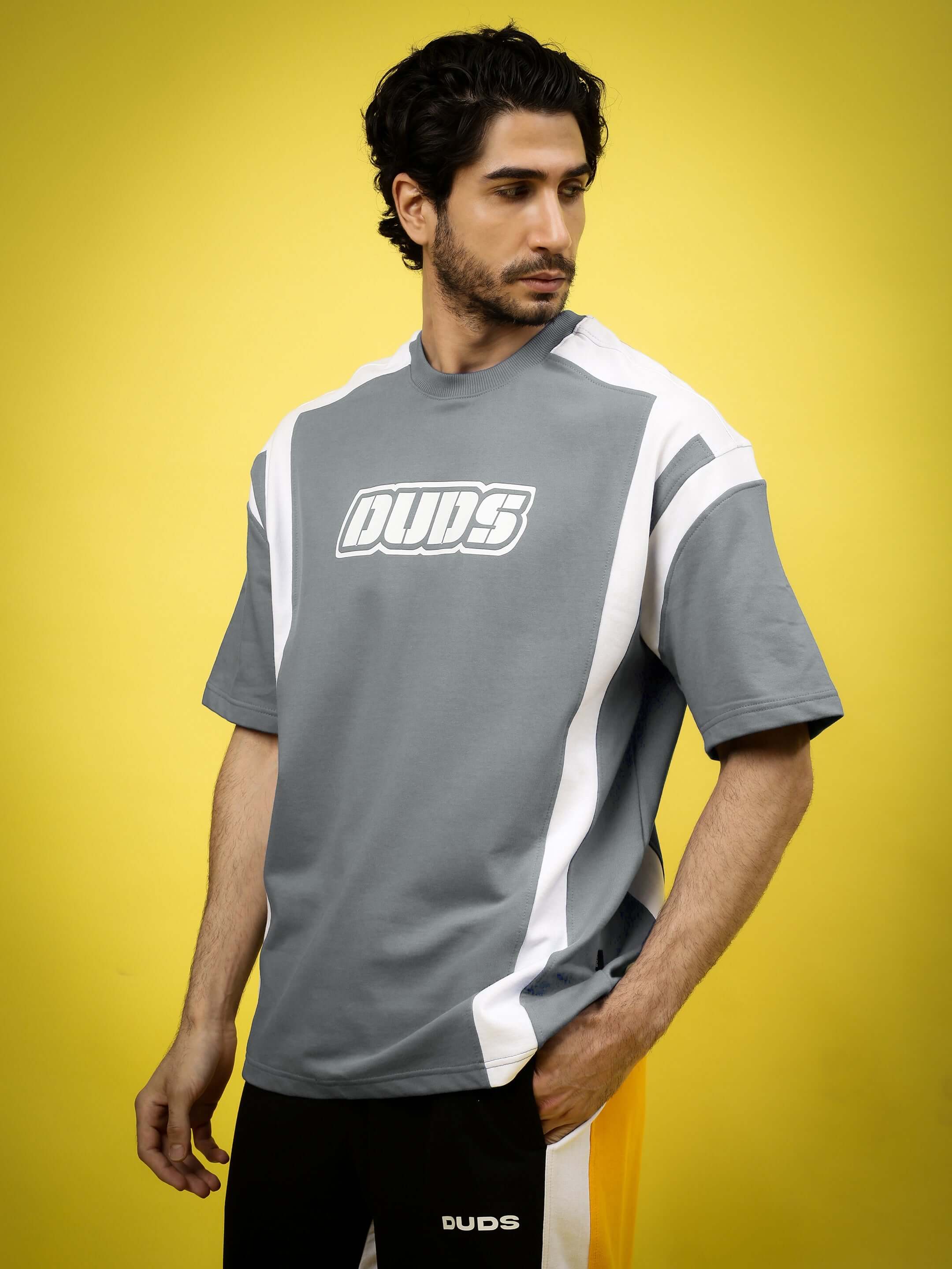 Man wearing NINJA STORM OVER-SIZED T-SHIRT GREY with graphic print against a yellow background