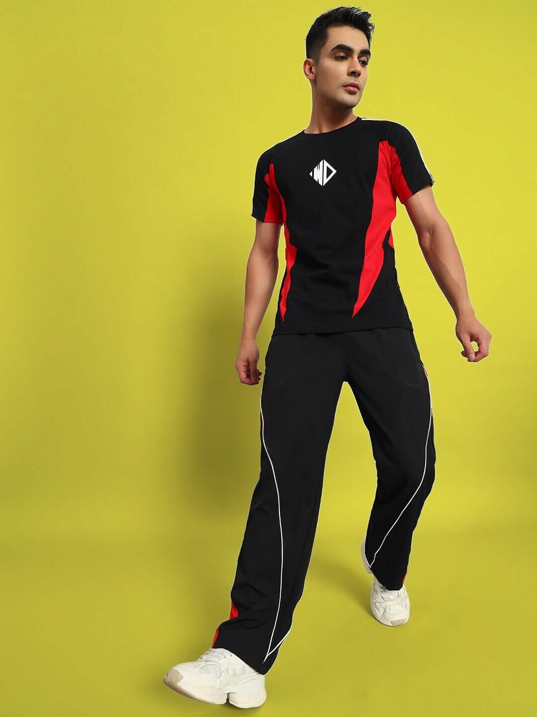 Model wearing NISSAN Parachute Cargo Pants in Black-Red, showcasing design and fit on a bright yellow background.