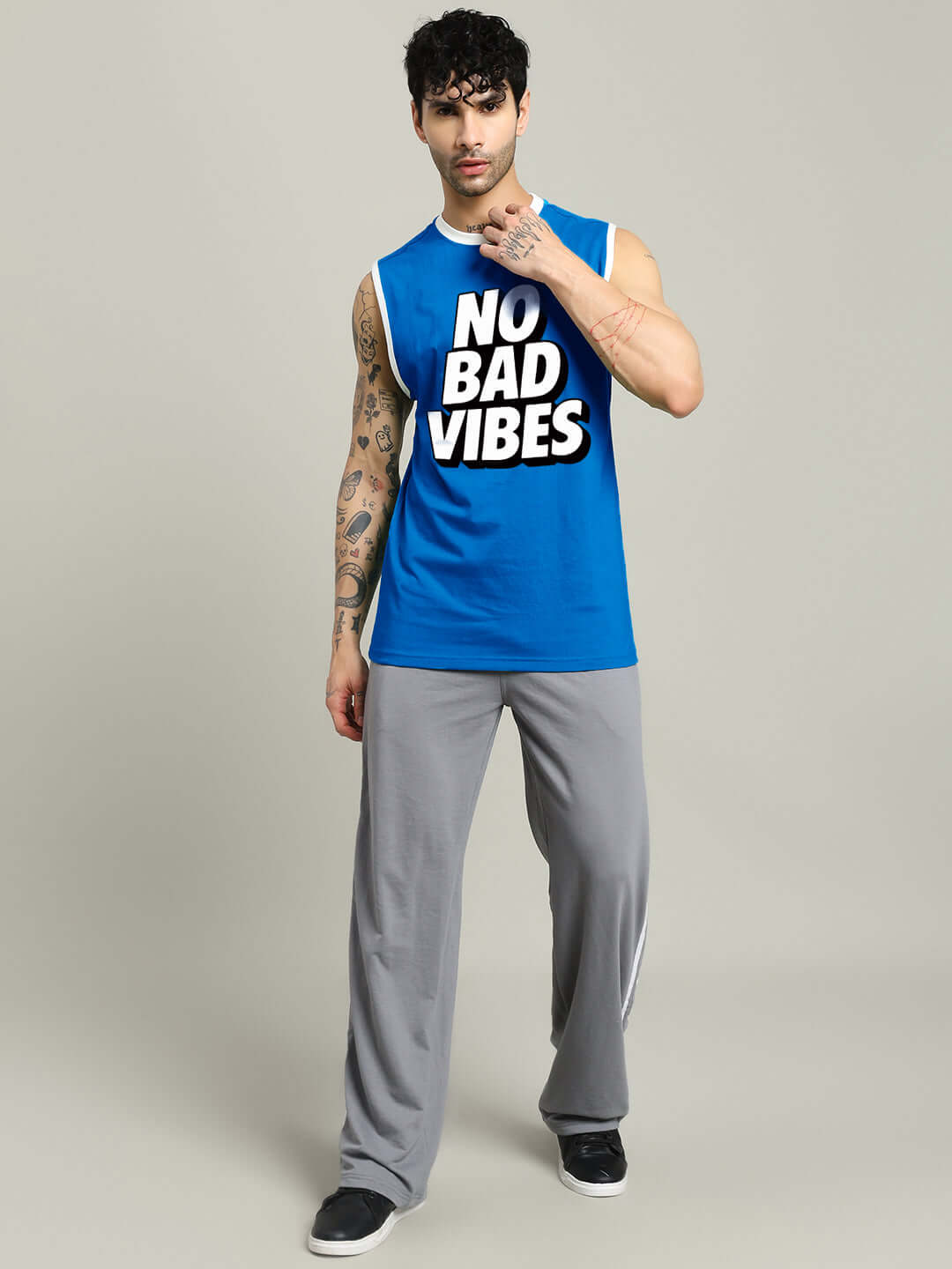 Man wearing NO BAD VIBES SLEEVLESS GYM T-SHIRT BLUE, showcasing bold workout apparel for fitness enthusiasts.