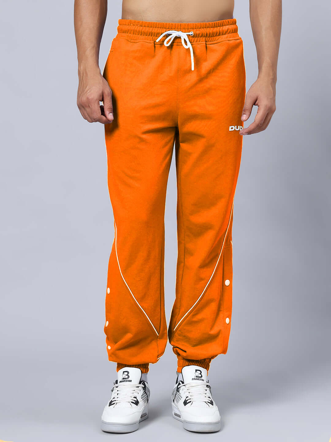 NO GRIT NO GLORY GYM RELAXED FIT CO-ORD SET BLACK-ORANGE pants close-up with white sneakers, bold athletic wear featuring orange color.