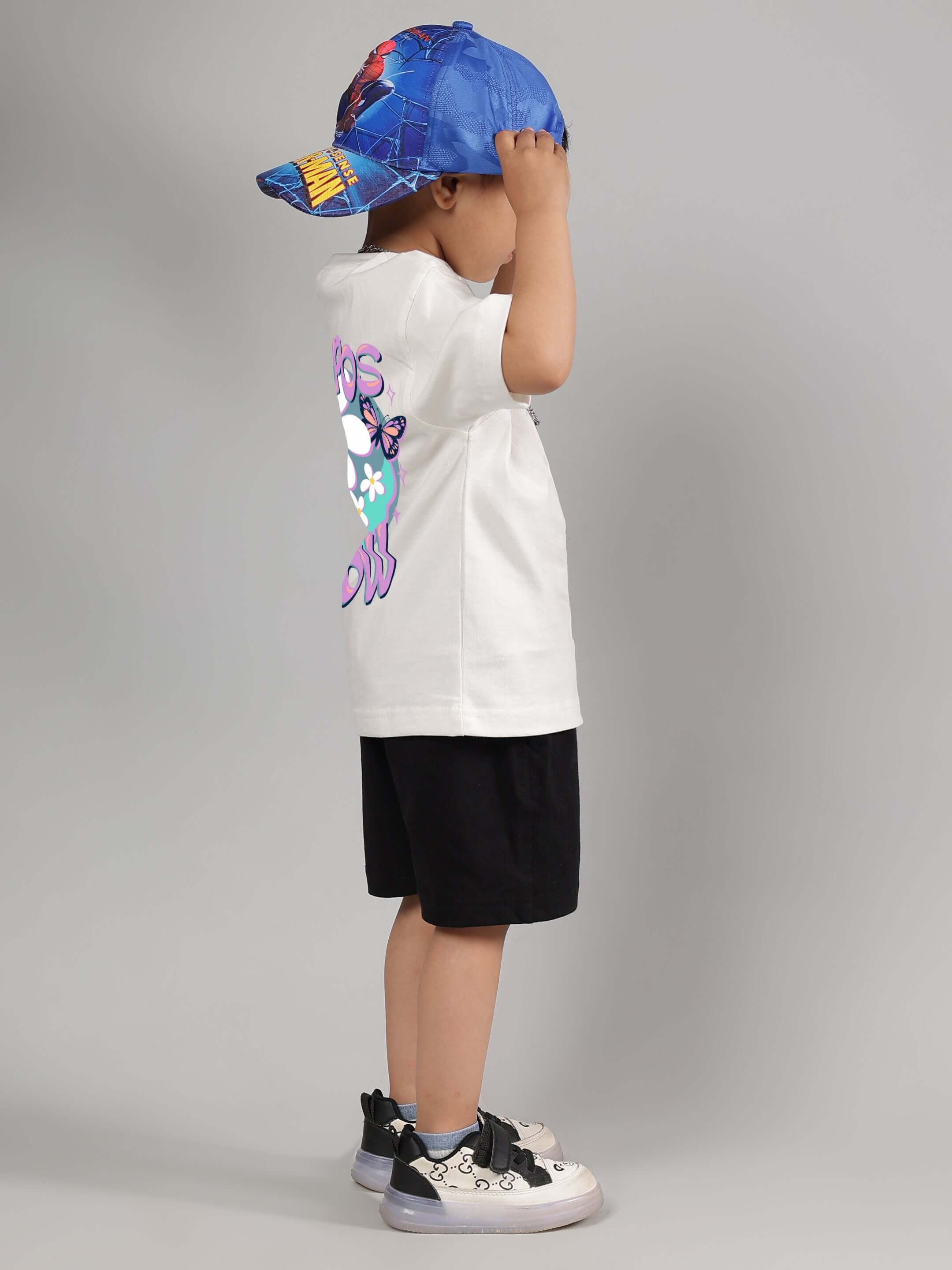 Child wearing NO POS Boys & Girls Black Shorts with colorful cap and sneakers.