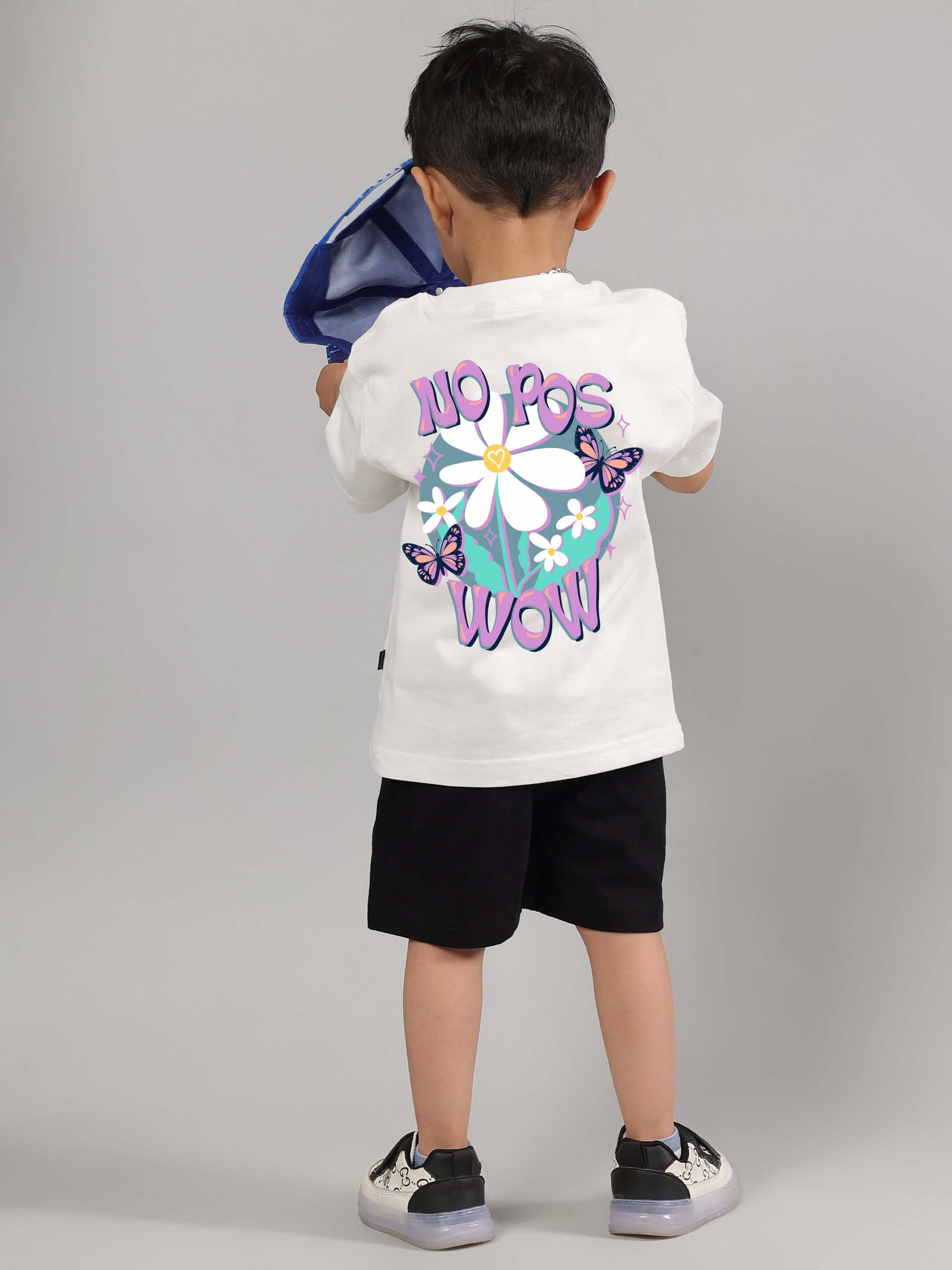 Child wearing No Pos Wow Co-ord for boys girls off-white black with floral graphic and butterflies.