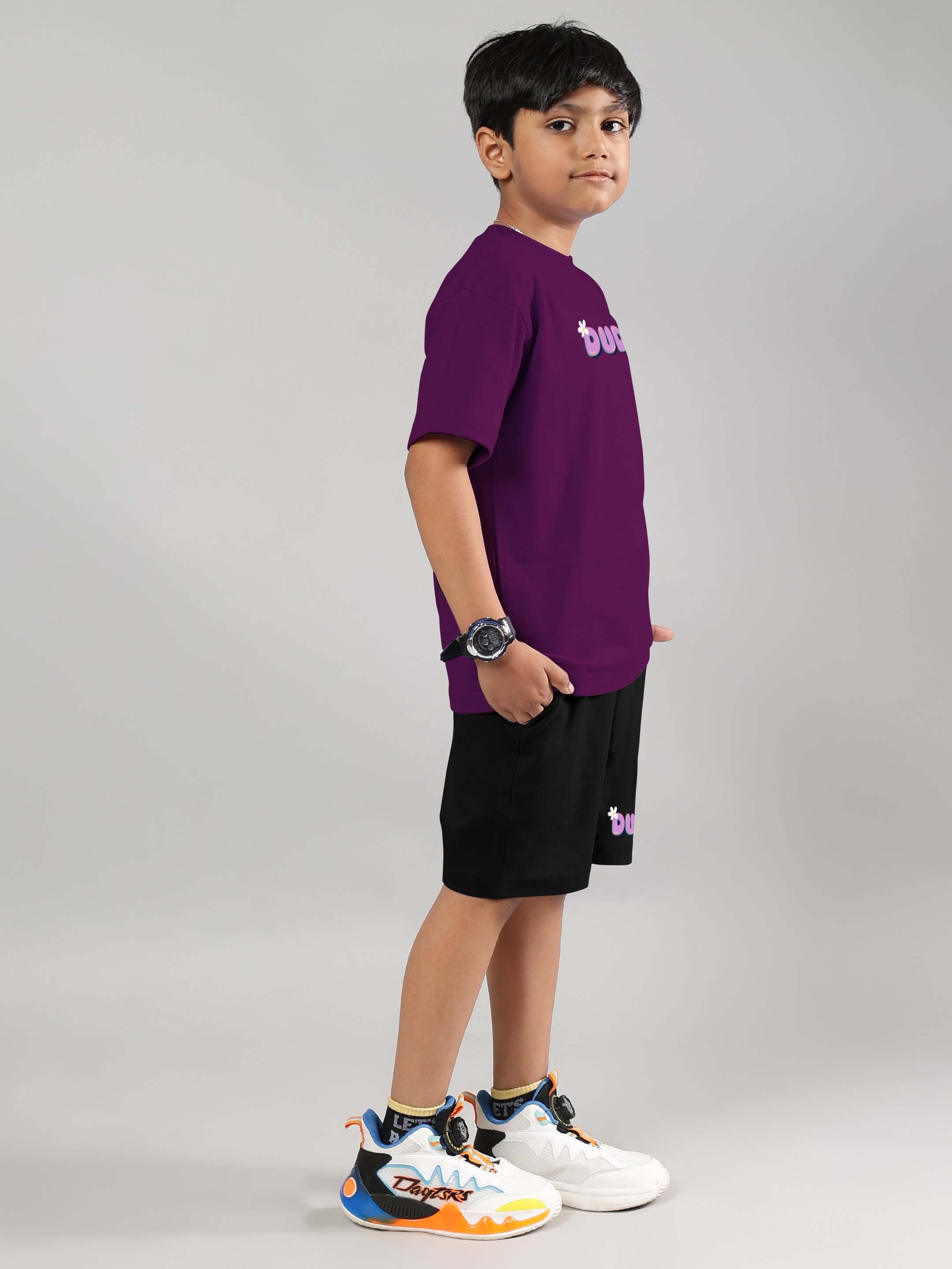 Young boy wearing NO POS WOW purple-black co-ord for kids featuring a comfortable fit, perfect for playful outings.