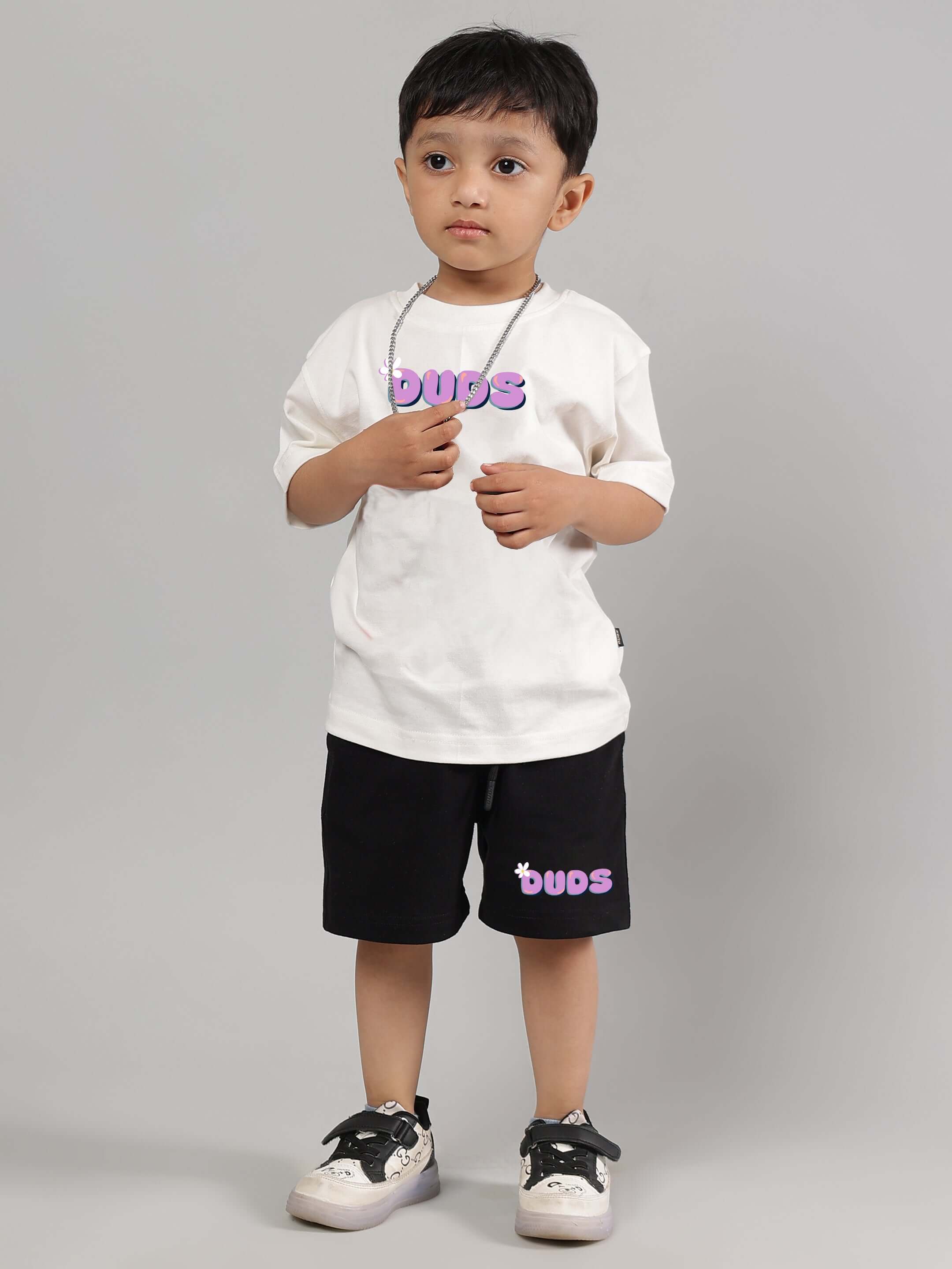 NO POS WOW CO-ORD FOR BOYS GIRLS OFF-WHITE BLACK unisex outfit featuring a child wearing off-white top and black shorts, stylish streetwear.