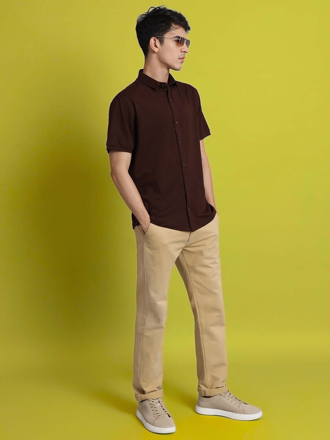 Man wearing NOIR Coffee Brown Shirt, half sleeves, slim fit, 4-way stretch, wrinkle-free, 100% cotton lycra, with beige pants.