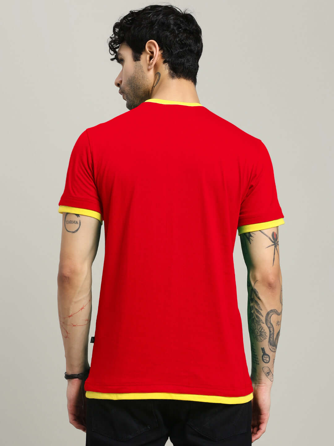 Back view of a man wearing a Noriba regular fit red T-shirt with yellow trim, crafted from premium 100% cotton fabric, bio-washed for comfort.