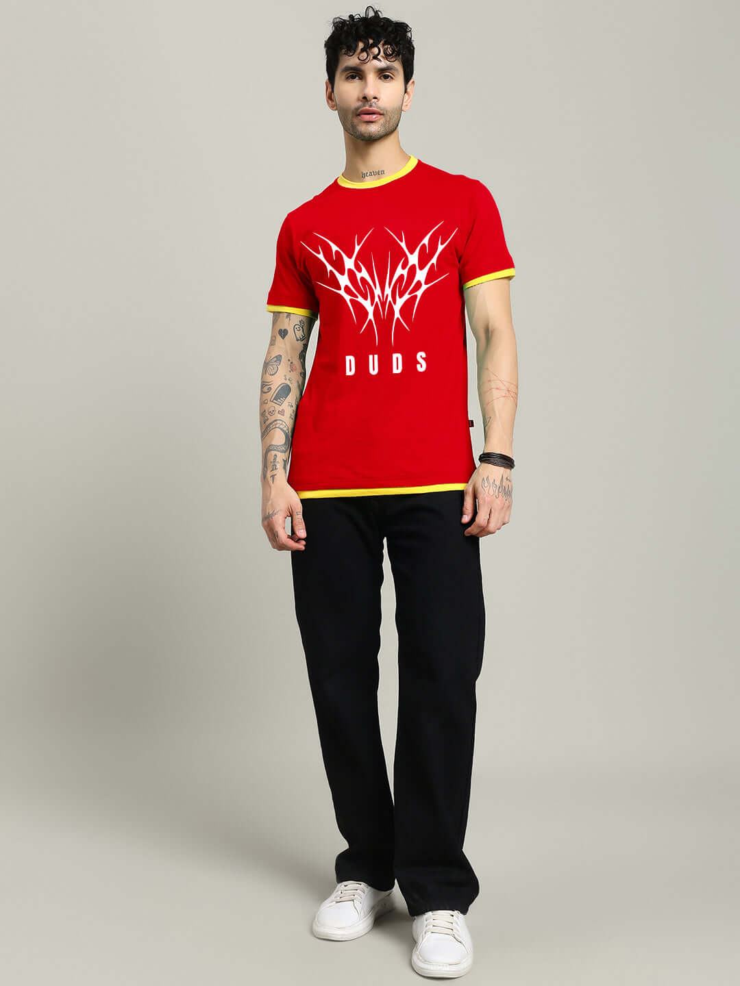 Man wearing NORIBA red regular fit T-shirt with graphic print, paired with black pants and white sneakers.