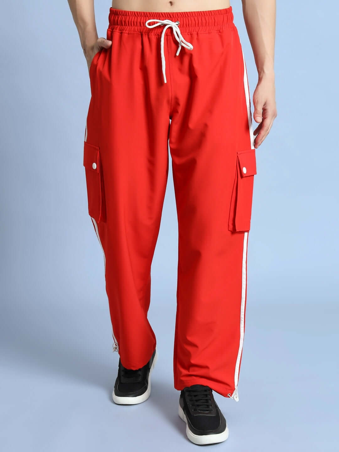 Man wearing NOVA relaxed fit cargo pants in red with white drawstring and side pockets.