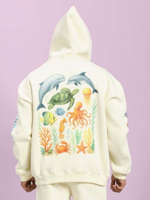 Off-white OCEAN BUDDIES OVERSIZED FLEECE HOODIE with playful ocean creatures on the back, perfect for cozy lounging and casual wear.