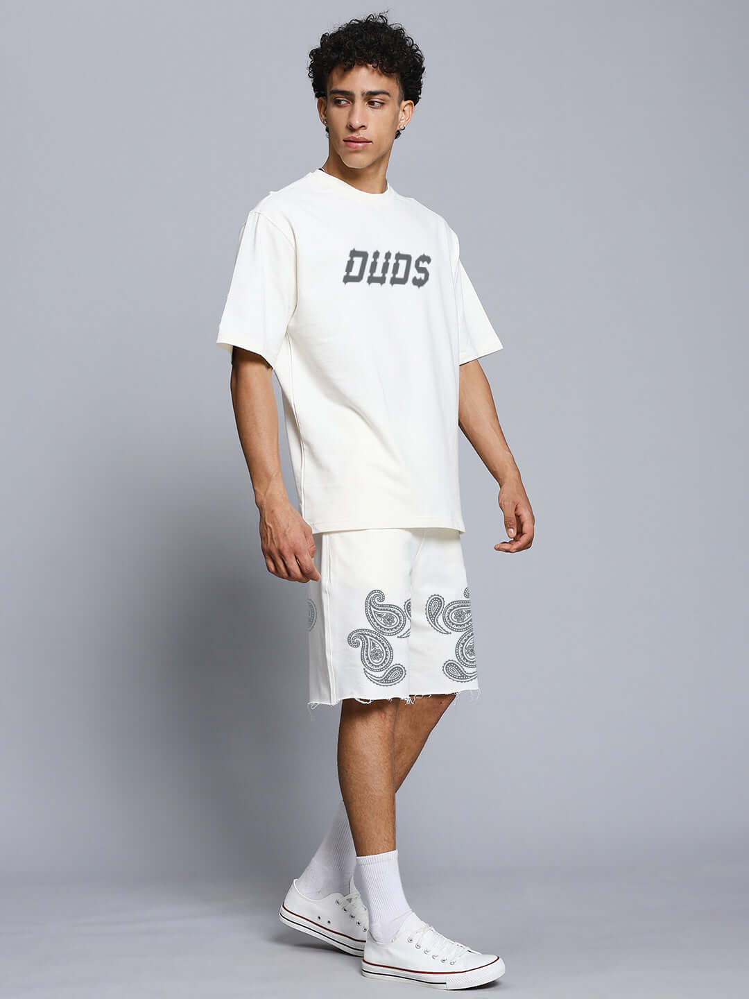 Model wearing MESSI PAISLEY PRINT CO-ORD SET OFF WHITE with oversized t-shirt and paisley shorts