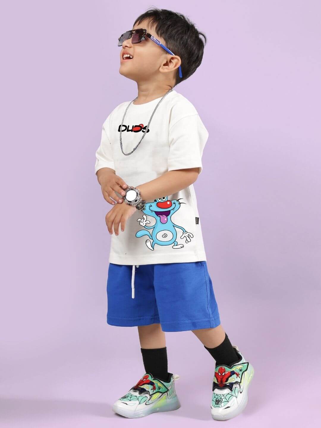 Child wearing Oggy printed co-ord set with off-white T-shirt and blue shorts, showcasing a fun cartoon style and comfortable fit.