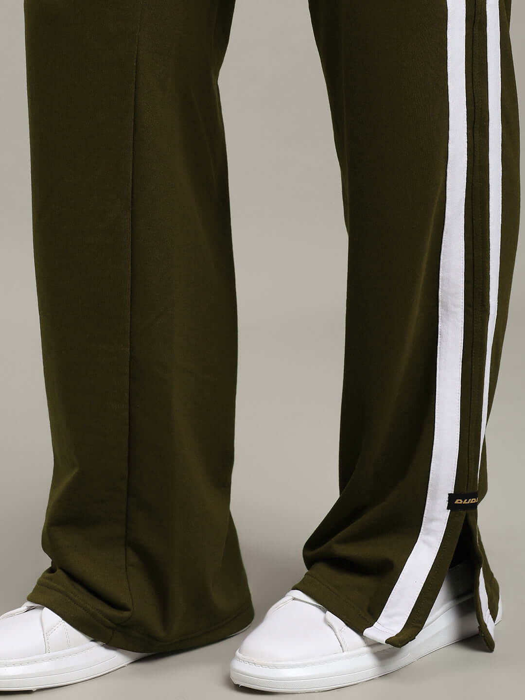 MOSCOW RELAXED FIT JOGGERS OLIVE GREEN with white stripe detail and comfortable fit, styled with white sneakers, perfect for casual wear.
