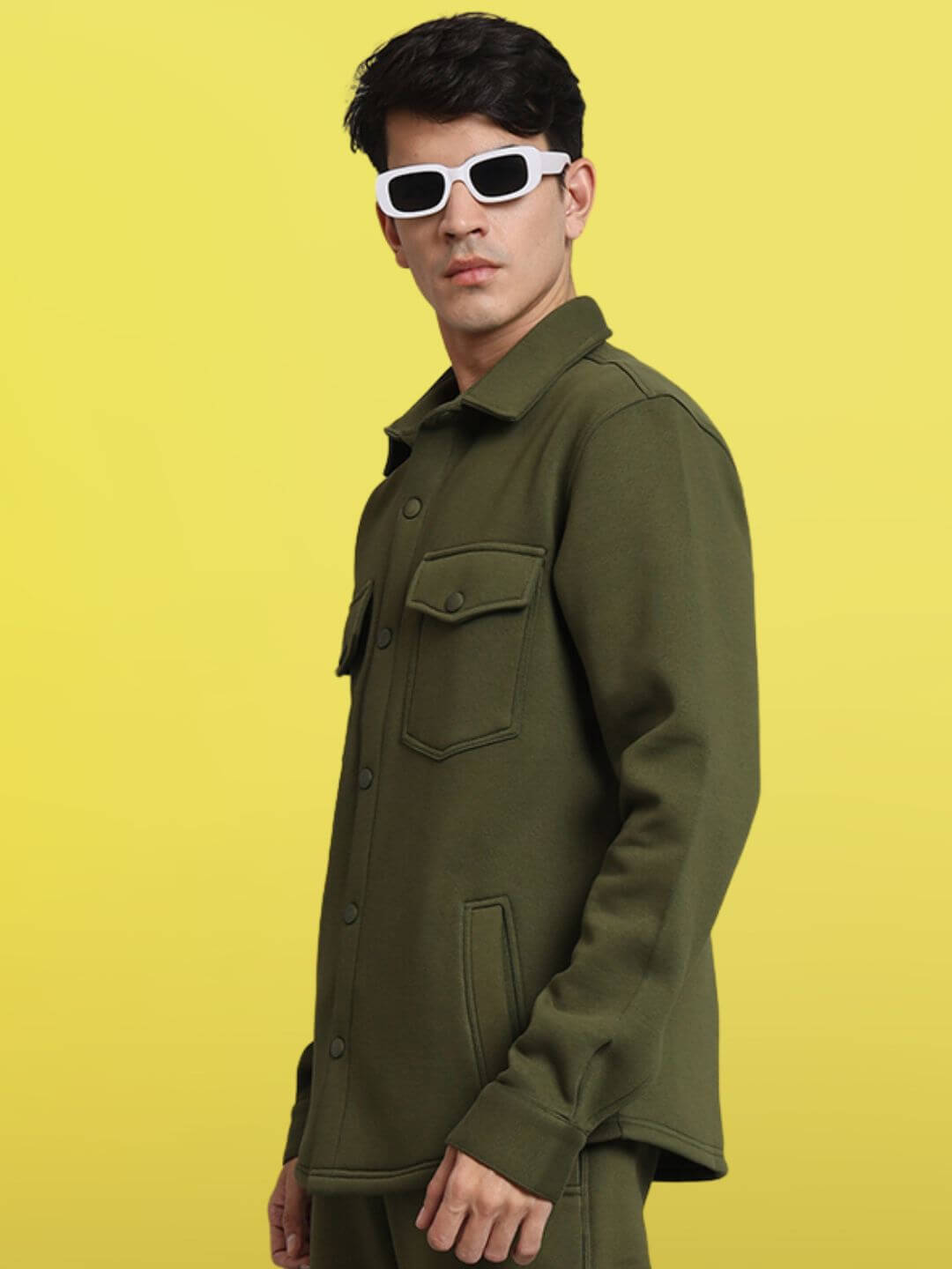 Model wearing Olive Green Relaxed Fit Full Sleeves Fleece Overshirt against yellow background