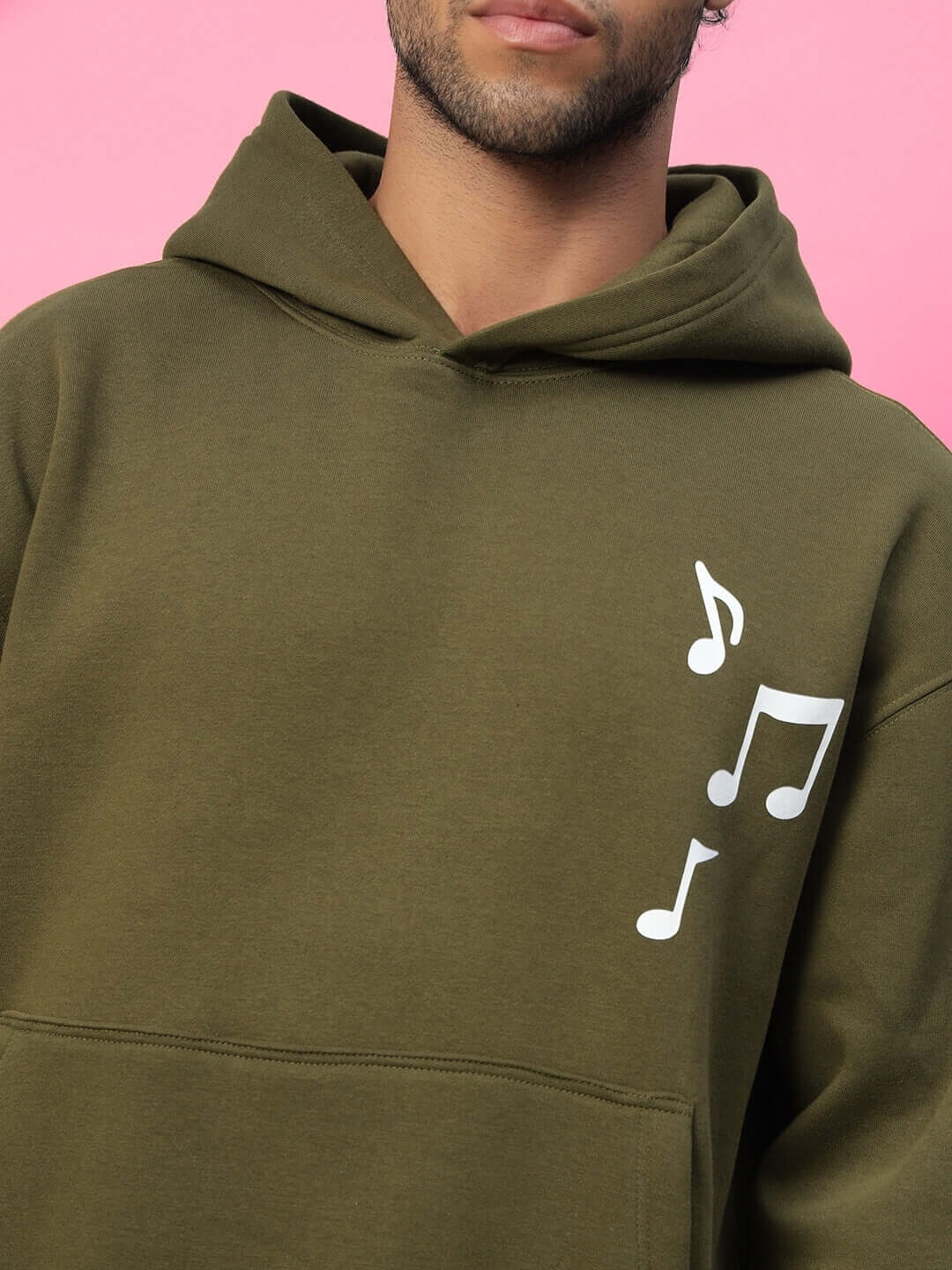 OPERA FLEECE HOODIE OLIVE GREEN with a musical note design against a pink background
