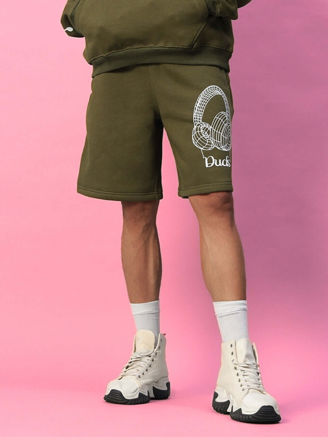 Model wearing OPERA FLEECE SHORTS OLIVE GREEN with white shoes, showcasing custom fit option available for orders.