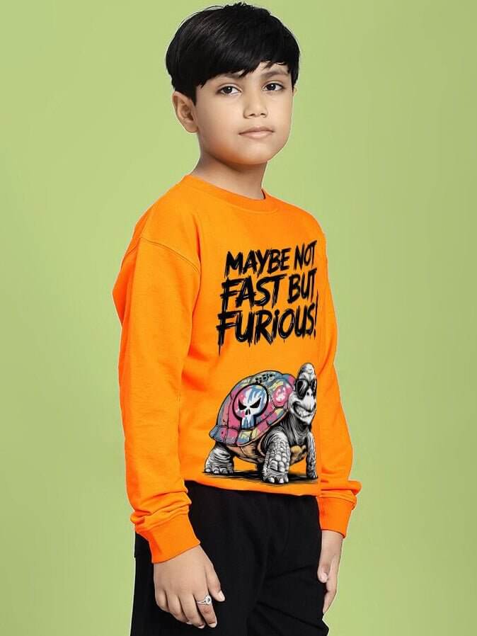 Boy wearing NOT FAST BUT FURIOUS PRINT SWEATSHIRT BOYS AND GIRLS ORANGE with turtle design, nature vibes.