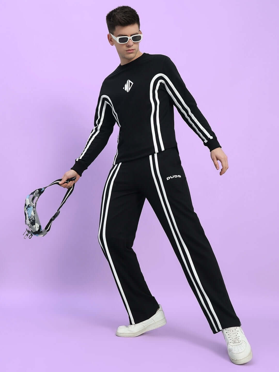 Model wearing black Outlook 2 Stripe Jogger by DUDS with white stripes, showcasing trendy athletic wear.