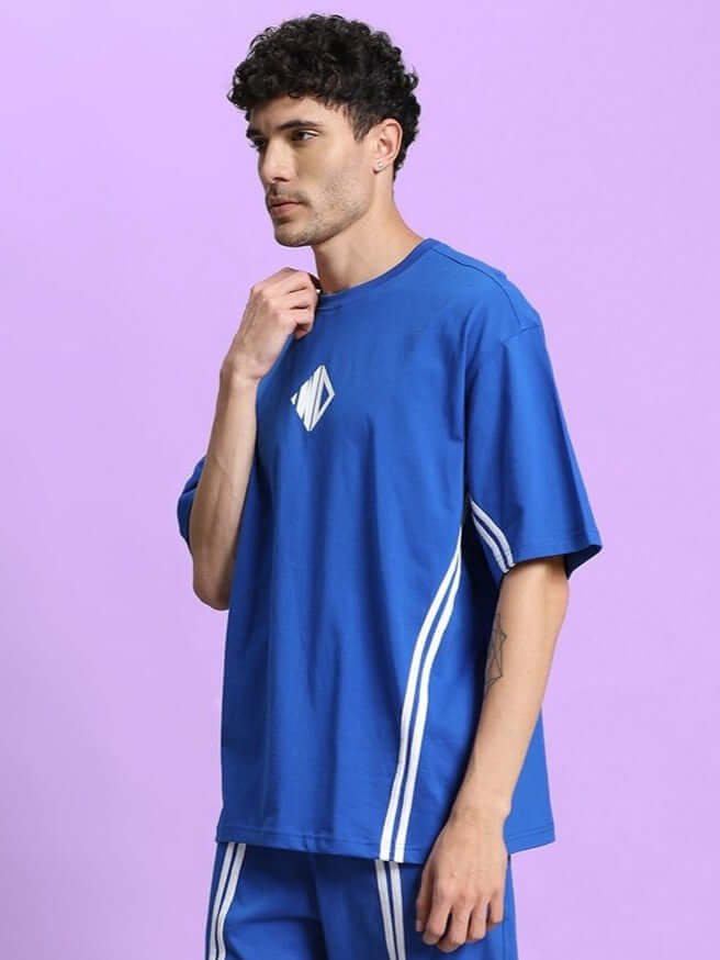 Man wearing OUTLOOK OVER-SIZED T-SHIRT ROYAL BLUE with white stripes, showcasing modern streetwear style in a vibrant royal blue shade.