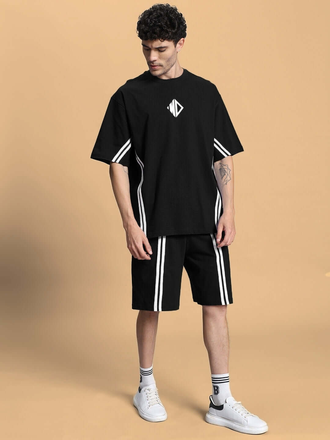 Model wearing OUTLOOK SUMMER CO-ORD SHORTS SET BLACK, featuring a sleek black oversized t-shirt and shorts, perfect for versatile street style.