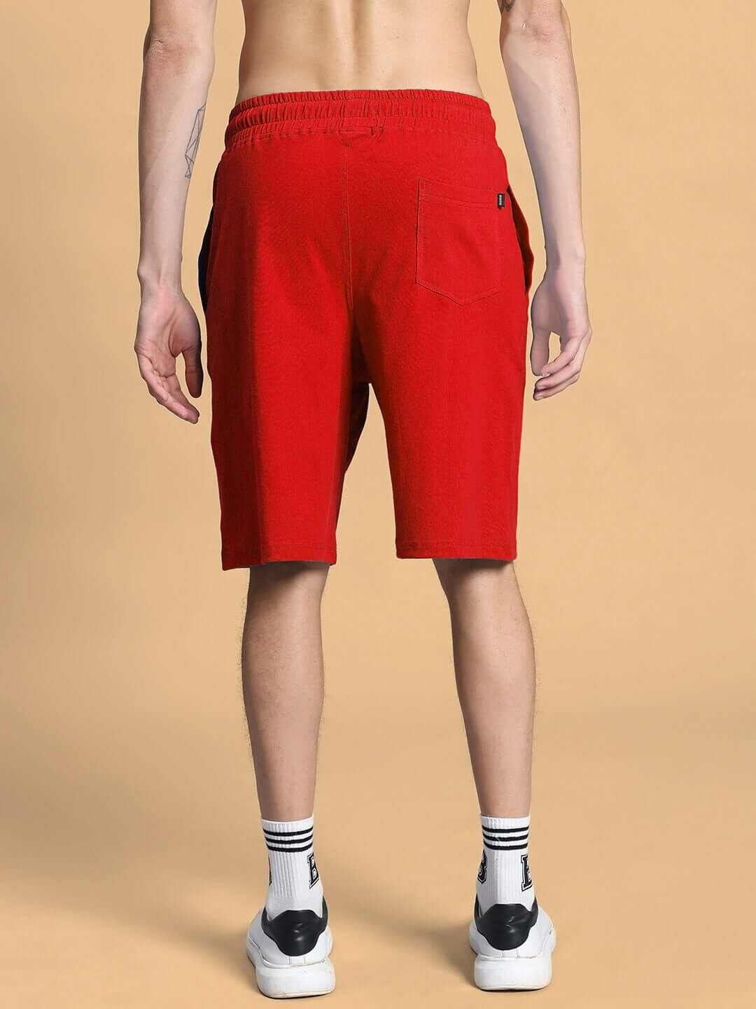 Back view of OUTLOOK SUMMER CO-ORD SHORTS SET RED showcasing relaxed-fit red shorts against beige background.