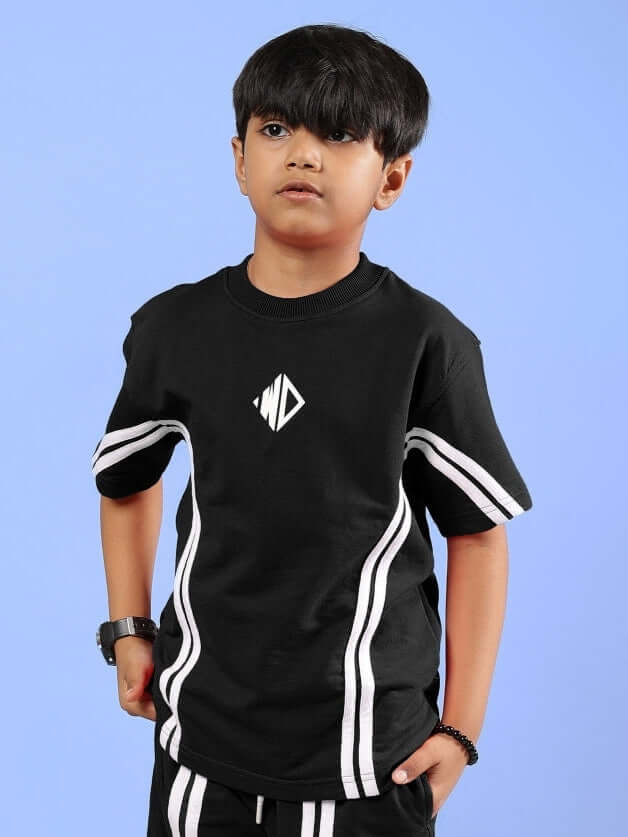 Child wearing OUTLOOK T-SHIRT FOR BOYS GIRLS BLACK, showcasing modern streetwear style with white stripe details on a blue background.
